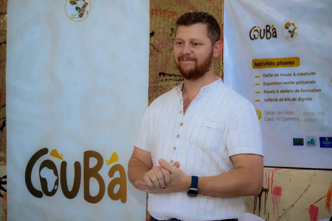 Un visiteur découvre les produits exposés devant une bannière COUBA.